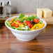 An American Metalcraft stoneware bowl filled with salad on a table.