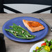 A plate of salad and cooked salmon on a Carlisle Ocean Blue melamine plate.