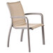 A Grosfillex Sunset Cognac outdoor stacking armchair with a metal frame.