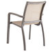 A Grosfillex Sunset Cognac outdoor stacking armchair with a beige seat and back on a white background.