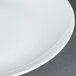 A close up of a CAC Majesty European Bone China coupe plate with a white rim.