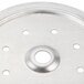 A close-up of a stainless steel circular plate with 8 holes in it.