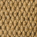 A close up of a beige carpet with a pattern of white threads.
