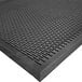 A close-up of a black rubber Cactus Mat with ridges and holes.