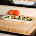 A white rectangular melamine tray with scalloped edges and a crackle finish.