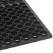 A black circular rubber mat with holes in it.