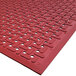 A red Cactus Mat VIP Guardian grease-proof floor mat with holes in the middle.