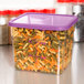A purple plastic Cambro food storage container with a purple lid filled with spiral pasta.