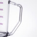 A clear polycarbonate measuring cup with a purple handle and purple measurement markings.