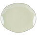 A close up of a white Tuxton China platter with a green rim.
