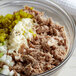 A bowl of chunk light tuna mixed with mayonnaise, onions, and celery.