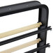 A black metal countertop rack with wooden bars for 3 rolls of paper.