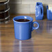 A Fiesta Lapis china mug filled with a blue liquid on a table.