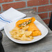 A Fiesta® White square luncheon plate with a sandwich and chips on it.
