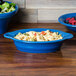 A blue Fiesta oval casserole dish with pasta and salad in it.