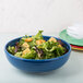 A close up of a salad in a blue Fiesta china bistro bowl.