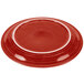 A red Fiesta Healthcare china plate with a white rim.