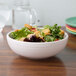 A white Fiesta medium china bistro bowl filled with salad with croutons.