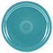 A turquoise plate with a circular pattern.