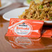 A packet of Kikkoman Teriyaki Marinade & Sauce next to a plate of food.