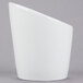 A Tuxton bright white tall slanted side dish with a curved edge on a gray surface.