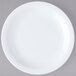 A white Carlisle bread and butter plate with a white rim on a gray surface.