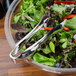 A bowl of salad with Fineline silver plastic serving tongs.
