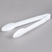 A pair of white plastic Fineline serving tongs.