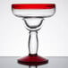 A Libbey margarita glass with a red rim and base.
