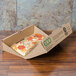 A GreenBox pizza in a cardboard box on a table.