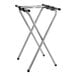 A black and chrome Lancaster Table & Seating double bar tray stand folded up on a table.