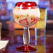A close-up of a Libbey cocktail glass with yogurt, strawberries, and cereal.