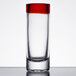 A close up of a Libbey shot glass with a red rim.