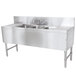 An Advance Tabco stainless steel underbar sink with 3 compartments, 2 drainboards, and a splash mount faucet.