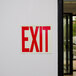 A Buckeye red and white exit sign label on a wall.