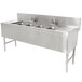 A stainless steel Advance Tabco underbar sink with 4 compartments, 2 drainboards, and 2 deck mount faucets.