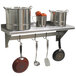 A stainless steel Advance Tabco wall shelf with pots and pans hanging from it.