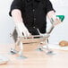 A person using Choice Prep suction cup feet to hold a French fry cutter on a table.