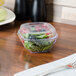 A salad in a plastic container with a clear lid.