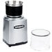 A Waring commercial spice grinder with a clear plastic container and black and silver lid.