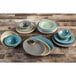 A table set with a group of Elite Global Solutions Cottage Vintage California melamine plates and bowls on a wood surface.
