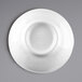 A white Elite Global Solutions melamine ramekin with a circular design on a white plate.