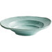 An Elite Global Solutions Della Terra mint green melamine bowl with an irregular shape and blue rim.