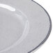 A close-up of an Elite Global Solutions Mojave gray crackle melamine plate with a curved line on the rim.