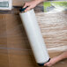 A person holding a roll of Lavex hand pallet stretch film.