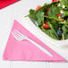 A plate of salad with strawberries, nuts, and a Creative Converting Candy Pink luncheon napkin.