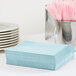 A stack of pastel blue Creative Converting luncheon napkins.