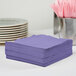 A stack of purple Creative Converting paper napkins.