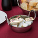 An American Metalcraft stainless steel balti dish filled with food on a table.