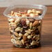 A 24 oz. square plastic deli container filled with nuts and raisins.